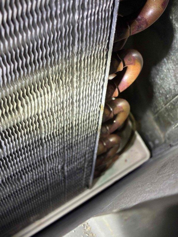 Responded to no cooling complaint and performed membership cooling system maintenance visit. Conducted thorough inspection of air handler components including evaporator coil and refrigerant lines. Evaporator coil showed signs of dust accumulation and minor discoloration on fins, indicating normal operational wear. Copper refrigerant lines displayed typical oxidation patterns consistent with system age. All components were accessible and properly housed within air handler cabinet. System inspected per maintenance agreement protocols. Customer concern addressed and recurring maintenance service completed as scheduled.