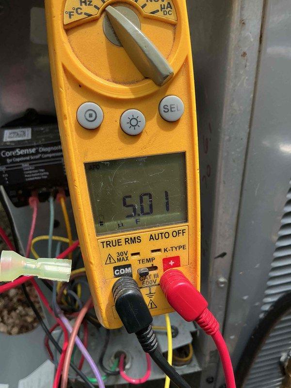 Completed tune-up service on residential outdoor air conditioning unit. Performed standard diagnostic testing including electrical measurements, with multimeter readings confirming proper voltage levels at 501V. Unit operating within normal parameters with no issues identified.