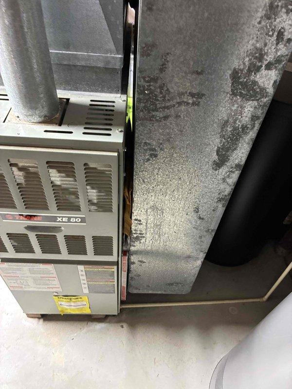 Completed comprehensive estimate for replacement of 30-year-old original HVAC system including natural gas furnace and air conditioning unit. Existing Trane XE 80 furnace located in basement showing age-related wear and operating at end of service life. Documented current equipment condition through detailed photography, noting system configuration, ductwork connections, and installation environment including concrete foundation with visible efflorescence indicating moisture concerns that should be addressed during replacement installation.