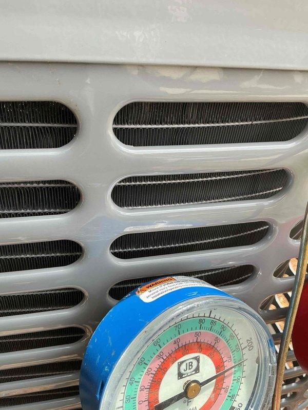 Completed comprehensive air conditioning tune-up including inspection of electrical components, contactor, and wiring connections within the unit's electrical compartment. Verified system pressures using manifold gauges and inspected condenser coil fins and exterior housing for proper operation. All components found to be functioning within normal parameters.