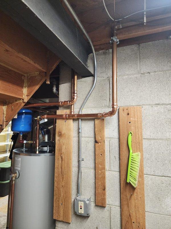 Installed 75-gallon residential water heater in basement utility area. Connected all supply and discharge plumbing lines with copper piping and appropriate brass fittings, installed expansion tank, and routed metallic vent pipe through floor joists to ensure proper exhaust ventilation. Unit tested and operational upon completion.