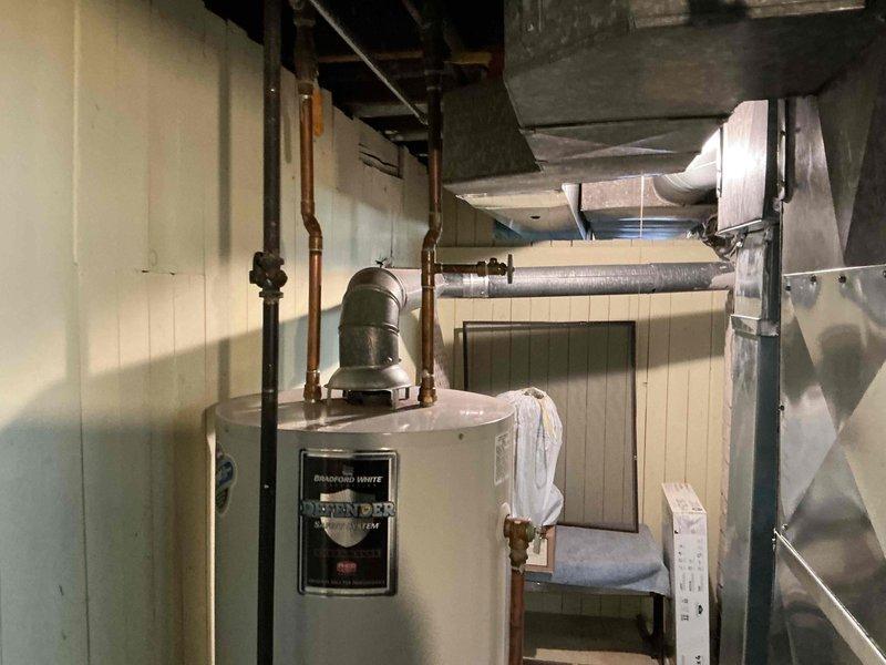 Completed estimate for water heater replacement in basement mechanical room. Existing unit showing signs of leakage requiring immediate replacement. Assessed installation area including existing copper piping connections, shut-off valves, and surrounding HVAC infrastructure to determine replacement specifications and material requirements.