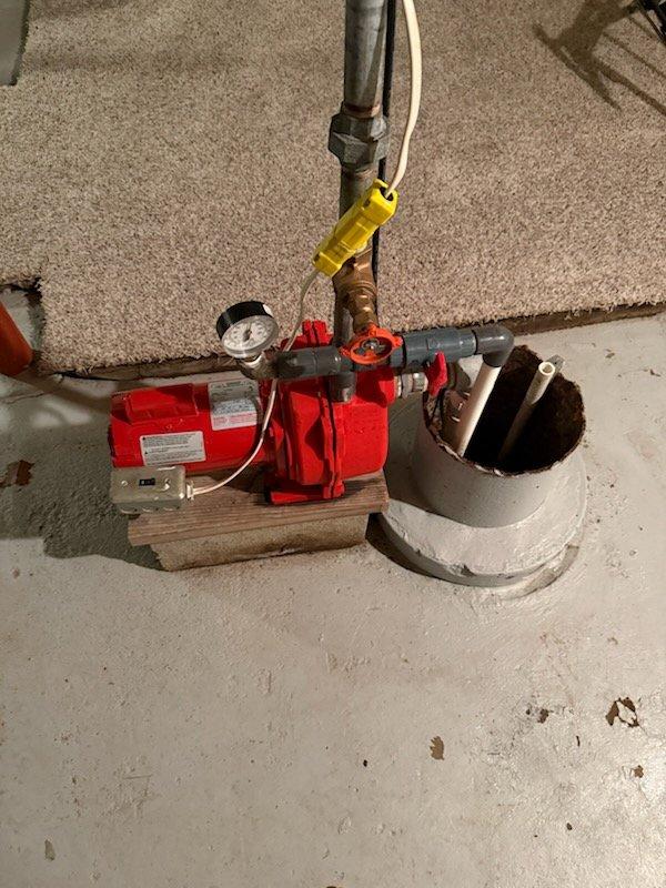 Responded to service call for dual sump pump system malfunction. Upon inspection, found submersible pump in primary sump basin operating ineffectively, creating agitation without proper water discharge. Diagnosed issue with pump impeller or intake obstruction preventing adequate fluid movement. 

Evaluated secondary deep pit external pump system with red Dayton motor unit mounted on wooden base. Confirmed pump operates correctly in manual mode but fails to activate automatically. Inspected electrical control box and identified faulty automatic float switch or control relay preventing activation during normal water level rise. Tested pressure gauge readings and verified all pipe connections, shut-off valves, and discharge lines for proper configuration.

Recommended replacement of submersible pump unit in primary basin and repair or replacement of automatic control components in external pump system. Scheduled preventive maintenance appointment to complete repairs and restore full autom