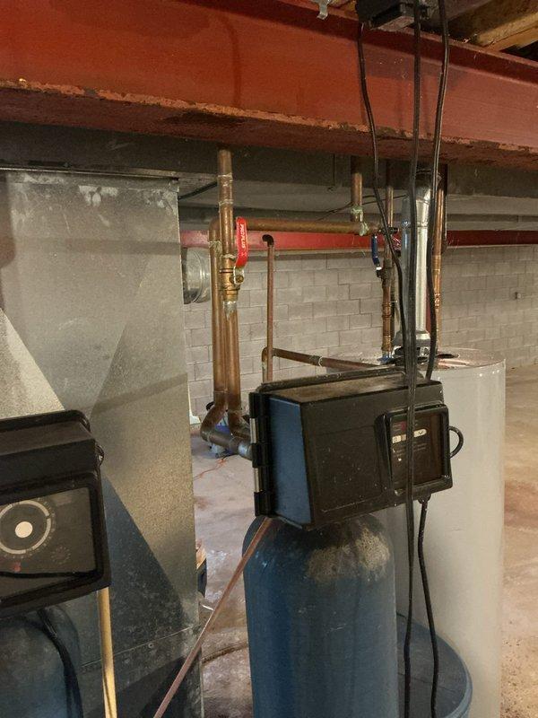 Responded to service call for water softener continuously running and requiring manual shutdown. Performed diagnostic inspection of water treatment system in basement mechanical room. Identified malfunction in regeneration cycle control causing unit to run without stopping. Inspected control valve assembly, timer mechanism, and associated plumbing connections. Evaluated copper piping configuration, bypass valves, and electrical components mounted on system. Assessed overall condition of water softener tank, resin bed functionality, and brine tank operation to determine root cause of continuous operation issue.