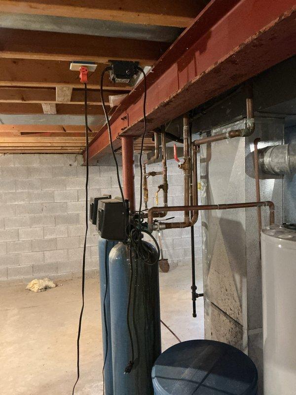 Responded to service call for water softener continuously running and requiring manual shutdown. Performed diagnostic inspection of water treatment system in basement mechanical room. Identified malfunction in regeneration cycle control causing unit to run without stopping. Inspected control valve assembly, timer mechanism, and associated plumbing connections. Evaluated copper piping configuration, bypass valves, and electrical components mounted on system. Assessed overall condition of water softener tank, resin bed functionality, and brine tank operation to determine root cause of continuous operation issue.