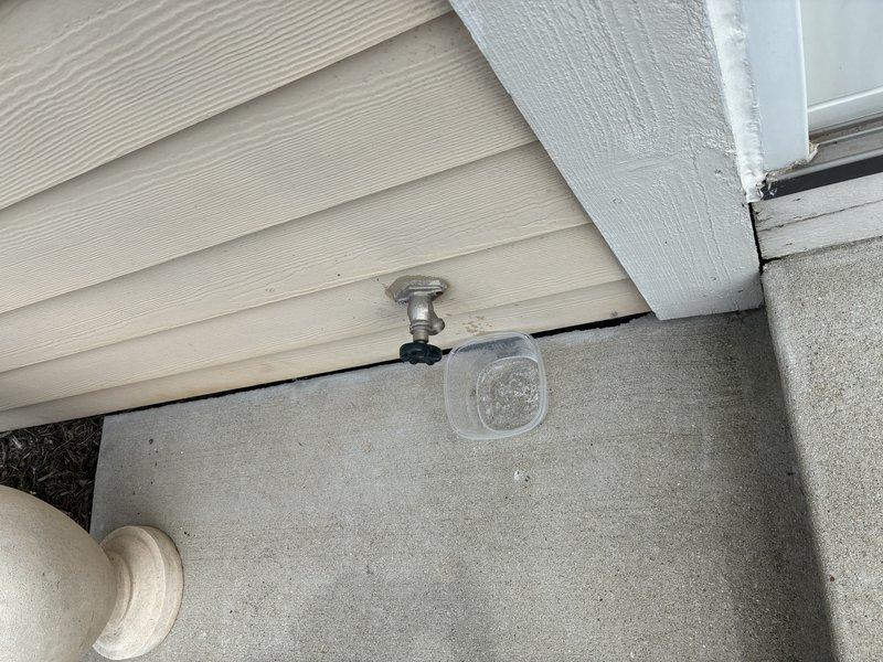 Diagnosed and repaired leaking outdoor hose bib by installing a new brass quarter-turn ball valve with yellow handle lever on the blue supply line in the crawl space. The new valve assembly was properly secured and tested to ensure no leaks at the exterior spigot location where the fixture emerges through the concrete foundation near the house siding.