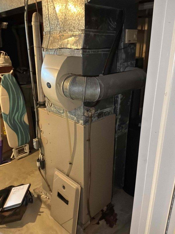 Completed estimate for full HVAC system replacement including natural gas furnace located in basement utility closet and outdoor air conditioning unit. Existing furnace showed signs of wear after limping through winter season. Assessed current installation configuration with furnace positioned in basement closet space with cylindrical ductwork elbow and outdoor condensing unit mounted on elevated white platform against house exterior with proper electrical disconnect and PVC condensate drainage. Provided pricing for complete system replacement with promotional upgrade package for air conditioning unit when purchased together with new furnace system.
