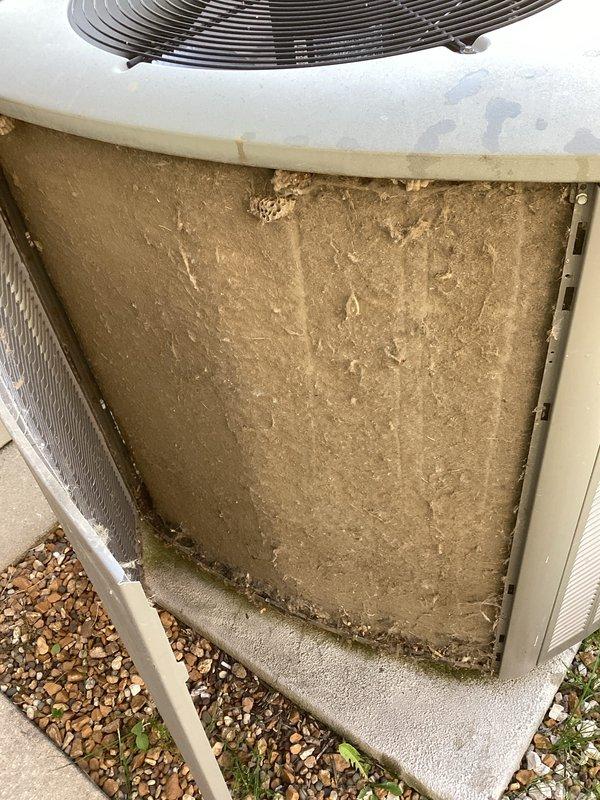 Responded to no cooling call at residential property. Upon inspection, found outdoor condenser unit with severely clogged and dirty air filter restricting airflow to the system. Filter exhibited heavy accumulation of dirt, dust, and debris with visible streaking patterns indicating extended period without maintenance. Cleaned filter and surrounding coil area, restoring proper airflow to unit. System tested and confirmed cooling operation restored to normal parameters.