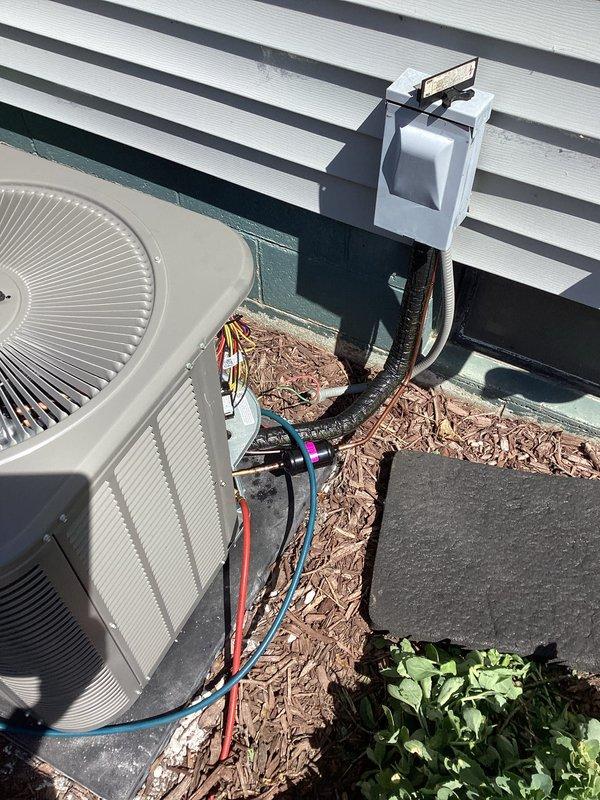 Completed full HVAC system installation including outdoor condensing unit and indoor evaporator coil paired with existing AIRTEMP furnace. Installed new condenser on concrete pad in exterior mulched area with proper clearances, mounted weatherproof electrical disconnect box on building exterior, and ran refrigerant line set with appropriate insulation connecting outdoor and indoor components. Indoor evaporator coil installed above furnace with proper condensate drainage connections. All refrigerant lines professionally routed and secured, system evacuated, charged to manufacturer specifications, and tested for proper operation. Electrical connections completed to disconnect and verified proper voltage and amperage. System startup performed with successful verification of cooling cycle, airflow, and temperature differential across coil.