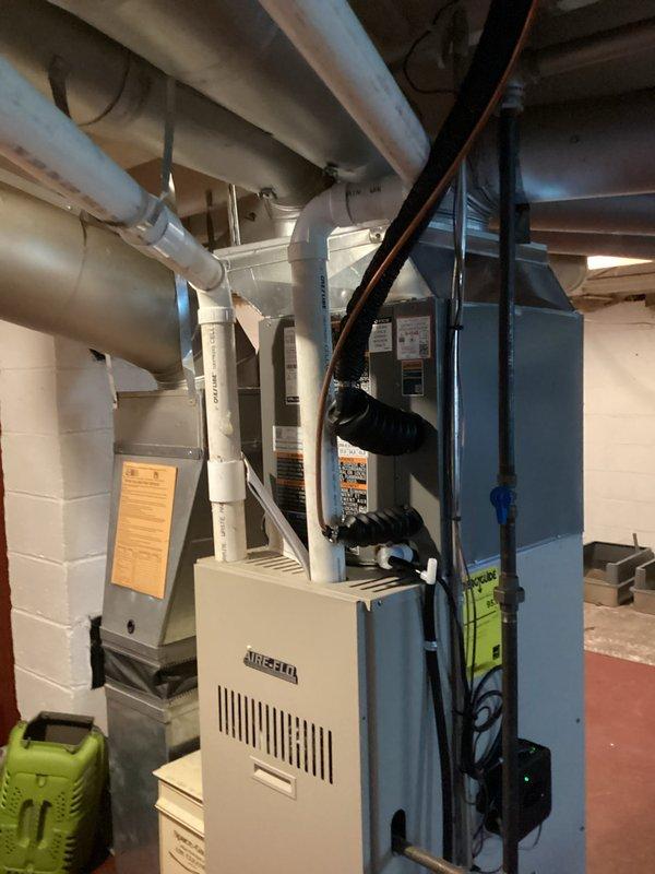 Completed full HVAC system installation including outdoor condensing unit and indoor evaporator coil paired with existing AIRTEMP furnace. Installed new condenser on concrete pad in exterior mulched area with proper clearances, mounted weatherproof electrical disconnect box on building exterior, and ran refrigerant line set with appropriate insulation connecting outdoor and indoor components. Indoor evaporator coil installed above furnace with proper condensate drainage connections. All refrigerant lines professionally routed and secured, system evacuated, charged to manufacturer specifications, and tested for proper operation. Electrical connections completed to disconnect and verified proper voltage and amperage. System startup performed with successful verification of cooling cycle, airflow, and temperature differential across coil.