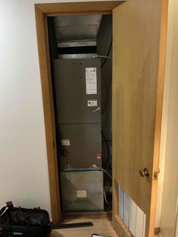 Responded to emergency service call during scheduled arrival window and performed comprehensive HVAC system assessment for replacement estimate. Documented existing vertically-stacked multi-component furnace system installed in residential utility closet, including air handler, control panels, and blower assembly with flexible metal ductwork and electrical connections. Captured detailed photographs of current equipment configuration, manufacturer specification labels, ventilation requirements, and spatial constraints to provide accurate replacement recommendations.