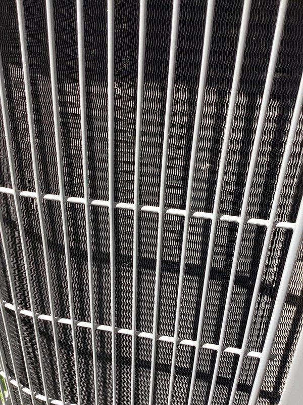 Performed comprehensive AC tune-up on residential cooling system. Inspected condenser coil assembly and protective grille, confirming clean condition with no debris accumulation or fin damage. Tested electrical components including capacitor and contactor using digital multimeter to verify proper operation and system functionality.