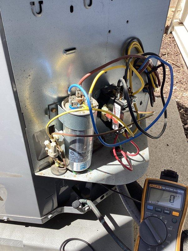 Performed comprehensive AC tune-up on residential cooling system. Inspected condenser coil assembly and protective grille, confirming clean condition with no debris accumulation or fin damage. Tested electrical components including capacitor and contactor using digital multimeter to verify proper operation and system functionality.