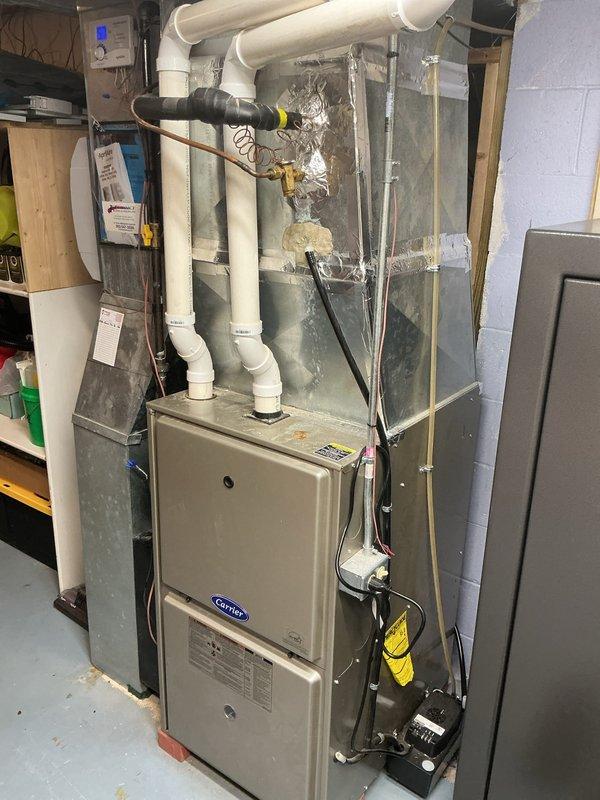 Completed scheduled cooling system maintenance visit under membership agreement. Performed comprehensive A/C tune-up on Lennox outdoor condenser unit and Carrier indoor air handler system. Inspected condenser cabinet noting significant weathering, surface oxidation, and mineral deposits on exterior panels consistent with extended outdoor exposure. Verified unit operation, checked refrigerant lines, electrical connections, and drainage systems. Examined indoor furnace and air handler components, confirmed proper PVC venting and condensate drainage configuration. All systems operational and functioning within normal parameters at time of service completion.