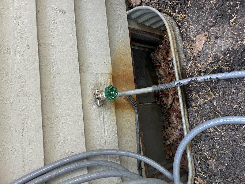 Diagnosed non-functional outdoor hose bib and associated shut-off valve. Inspection revealed failed interior shut-off valve with corroded copper piping connections within cabinet enclosure. Replaced defective shut-off valve assembly and repaired exterior hose bib mounting at foundation level, addressing water staining on siding caused by previous fixture failure. Tested system for proper operation and verified leak-free connections at all points.