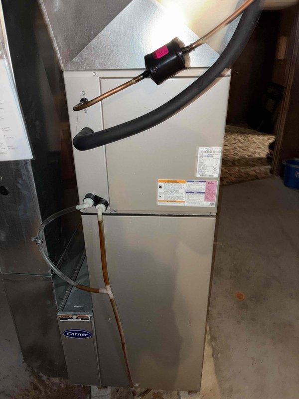 Completed prepaid membership cooling maintenance visit on residential HVAC system. Performed comprehensive inspection of indoor furnace unit and outdoor condensing unit, verified refrigerant pressures using manifold gauge set with readings within manufacturer specifications. Documented equipment condition with photos showing proper installation and operational status of Carrier system components, confirmed all safety labels present and system operating normally for continued seasonal cooling performance.