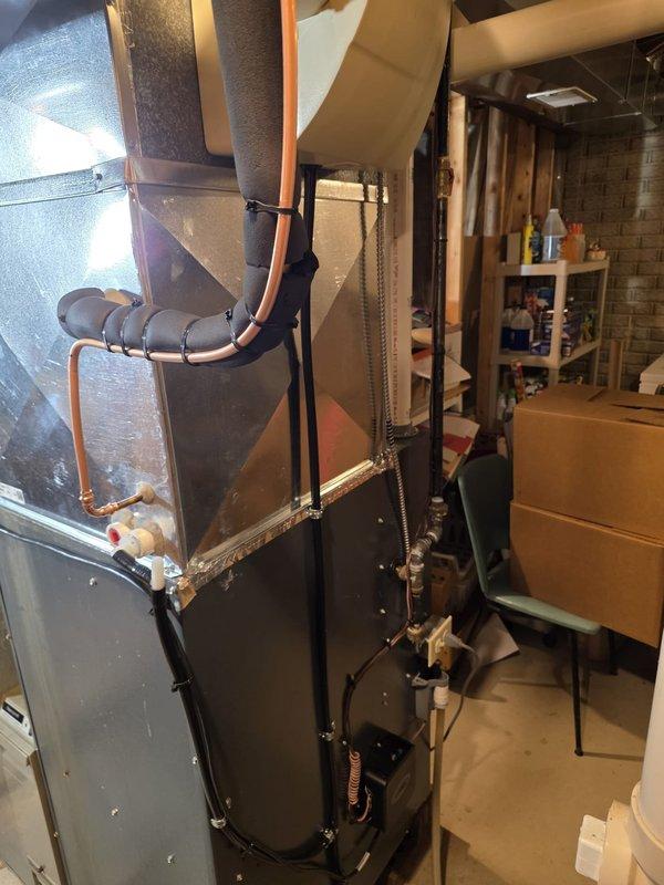Completed full air conditioning and evaporator coil replacement in residential basement utility area. Removed existing equipment and installed new A/C system with matching indoor coil unit mounted atop existing furnace. Connected copper refrigerant lines with proper bends and routing, integrated new coil with existing ductwork using metallic transitions and proper insulation wrap. Verified all electrical connections, tested system operation, and confirmed proper airflow through supply plenum. Installation meets manufacturer specifications and local code requirements.