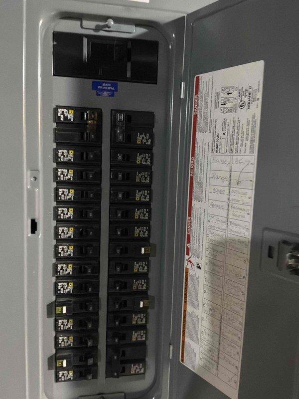 Conducted on-site evaluation of existing air conditioning system for proactive replacement estimate. The current outdoor condensing unit, which has been in service for over 20 years, remains operational but has reached the end of its expected service life. Documented existing equipment installation including electrical panel configuration and outdoor unit placement on concrete pad adjacent to brick exterior wall. Photographed circuit breaker panel showing current electrical service and outdoor condenser unit positioned in landscaped area with proper clearances. Provided comprehensive replacement options and recommendations for new high-efficiency cooling system to ensure continued reliable operation and improved energy performance.