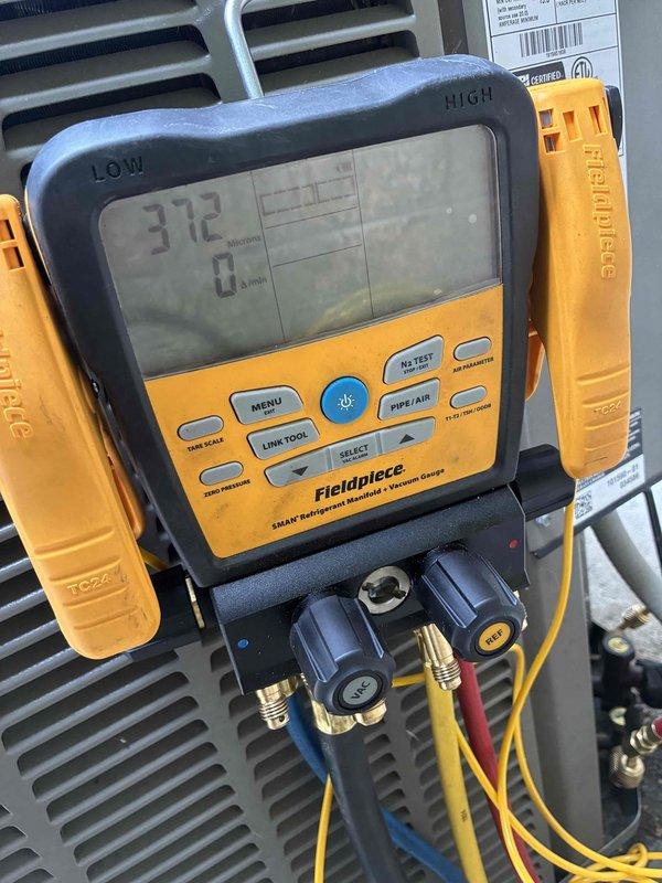 Completed refrigerant recovery, evacuated system to 312 microns to verify leak-free operation and remove moisture contamination, and installed liquid line filter drier. System held vacuum successfully, confirming integrity of repairs and readiness for refrigerant recharge.