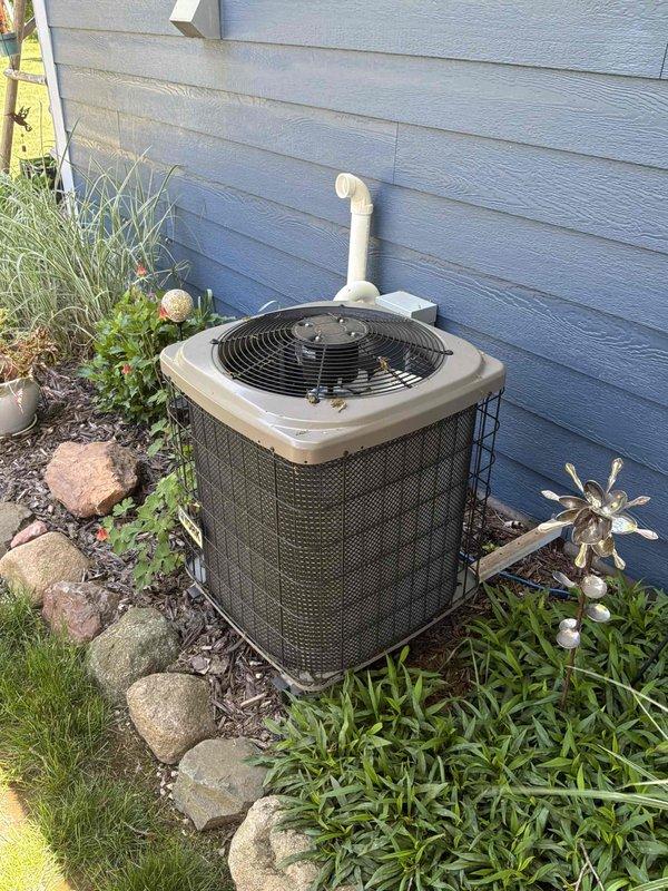 Conducted comprehensive assessment of existing residential HVAC system including outdoor condenser unit and indoor air handler for replacement estimate. The current air conditioning system has reached end of service life and requires full replacement. Documented existing equipment configuration including outdoor condenser unit positioned on gravel pad with landscaping integration, copper refrigerant line routing, and indoor air handler installation in mechanical room with associated ductwork connections. Evaluated forced air furnace system compatibility and provided detailed replacement recommendations for complete AC system upgrade to restore reliable cooling operation.