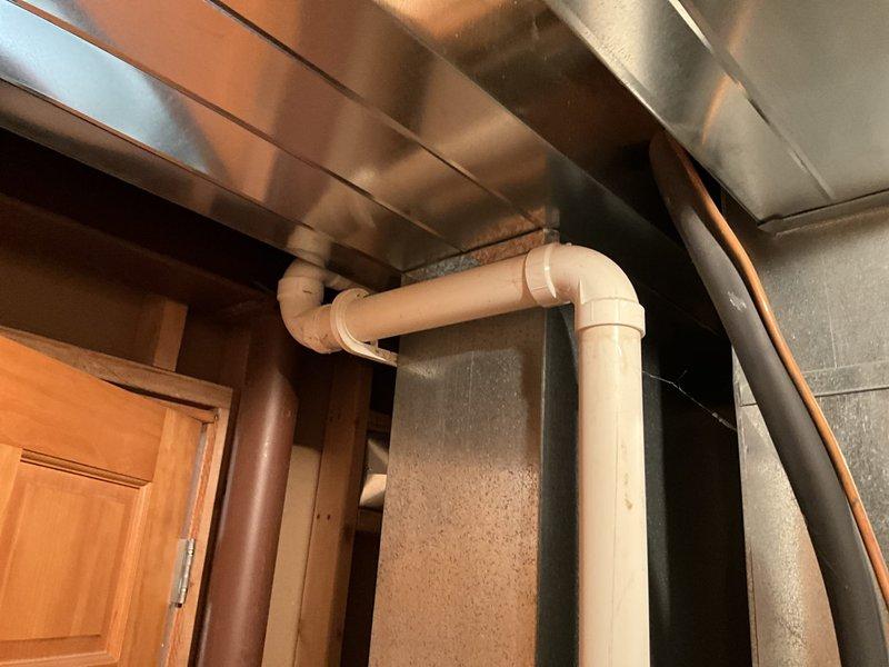 Conducted estimate for replacement of 21-year-old air conditioning system and natural gas furnace located in lower level condo. AC unit experiencing failure, running for less than one minute before shutting down, indicating end of service life. Evaluated existing outdoor condenser unit and indoor furnace installation, documented current system configuration including ductwork and drainage components, and provided replacement options for complete HVAC system upgrade.
