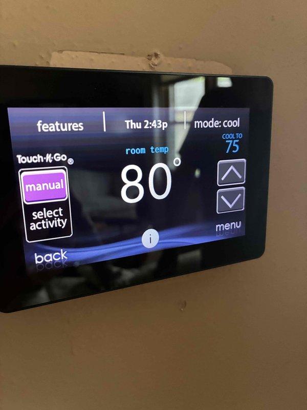 Attempted system startup on newly installed air conditioning unit but was unable to complete commissioning due to ambient temperature being too low for proper refrigerant charging and performance verification. Connected manifold gauges and diagnostic equipment to outdoor condensing unit in preparation for startup procedures. Observed indoor thermostat displaying 80°F room temperature in cooling mode with setpoint of 75°F. Will need to return when outdoor ambient temperature reaches approximately 80°F to properly charge system, verify refrigerant pressures, check superheat and subcooling values, and complete full startup checklist per manufacturer specifications.