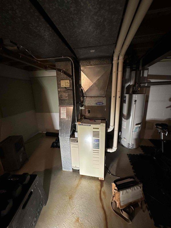 Completed estimate for full HVAC system replacement at residential property. Assessed non-functional furnace and underperforming air conditioning system in basement mechanical room. Documented existing Carrier equipment configuration, ductwork layout, and clearances for replacement unit specifications.