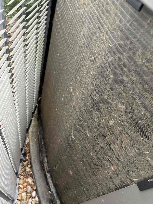 Completed annual tune-up on outdoor condensing unit. Unit was found with heavy dirt and debris accumulation on condenser coil and surrounding components, along with leaves lodged in fin areas. Performed thorough cleaning of condenser coils, removed all organic debris from unit interior and base, and cleared obstructions from airflow pathways to restore proper heat exchange efficiency and system performance.