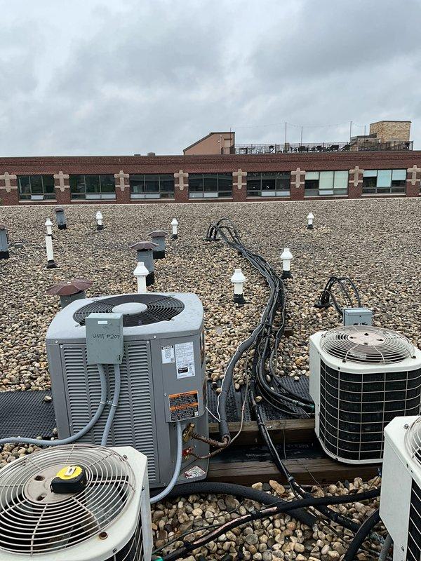 Conducted comprehensive assessment of existing HVAC system in condominium unit requiring rooftop condenser replacement and natural gas furnace replacement. Accessed rooftop equipment via stairway and hatch to evaluate multiple condenser units positioned on gravel surface with existing refrigerant lines and electrical connections. Evaluated natural gas furnace located above bathroom, accessible through bathroom panel requiring 6-foot ladder for proper access. Documented current system configuration including conduit routing, electrical disconnects, and equipment placement on wooden platforms with protective rubber matting. Provided detailed replacement estimate for both furnace and air conditioning condenser with specifications for proper installation access requirements.