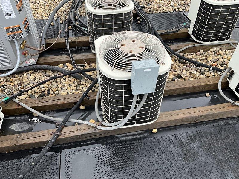 Conducted comprehensive assessment of existing HVAC system in condominium unit requiring rooftop condenser replacement and natural gas furnace replacement. Accessed rooftop equipment via stairway and hatch to evaluate multiple condenser units positioned on gravel surface with existing refrigerant lines and electrical connections. Evaluated natural gas furnace located above bathroom, accessible through bathroom panel requiring 6-foot ladder for proper access. Documented current system configuration including conduit routing, electrical disconnects, and equipment placement on wooden platforms with protective rubber matting. Provided detailed replacement estimate for both furnace and air conditioning condenser with specifications for proper installation access requirements.