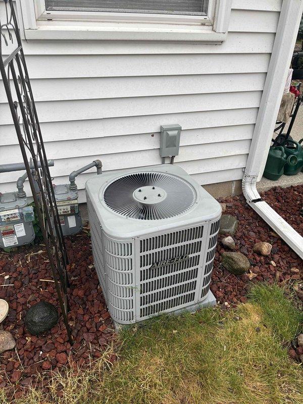 Completed annual tune-up on residential air conditioning system. Performed standard maintenance procedures including temperature differential measurements across the evaporator coil, recording 52.8°F reading indicating proper system performance. Inspected outdoor condensing unit, verified proper operation of fan assembly, checked electrical connections at disconnect box, and confirmed adequate clearance and airflow around unit with satisfactory mulch bed maintenance.