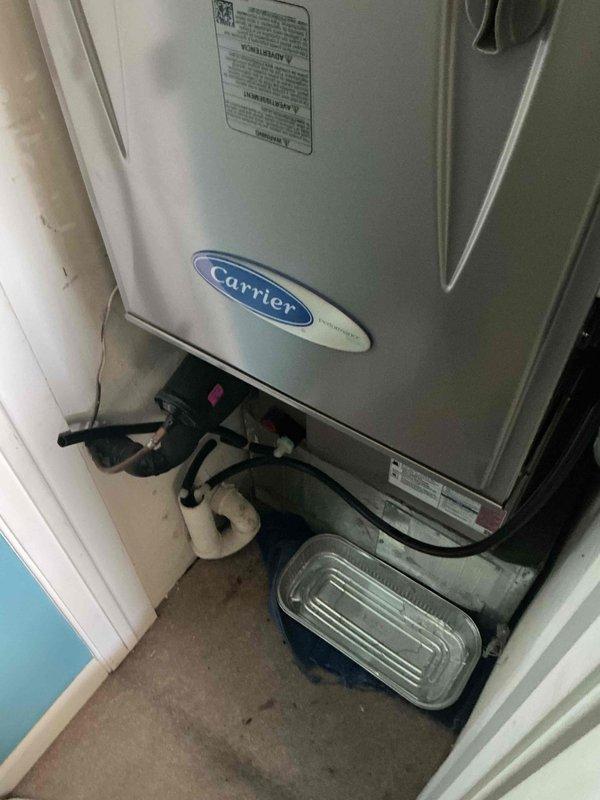 # HVAC Service Call - No Cooling Issue

Responded to no cooling complaint on aging Carrier air handler unit located in interior mechanical closet. Upon arrival, performed comprehensive system diagnostics to identify root cause of cooling failure. 

Conducted visual inspection of equipment revealing unit exceeding 10-year service life with signs of normal wear and accumulated debris around base and floor area. Inspected condensate drainage system including drain pan and associated plumbing connections. Evaluated black flexible supply and return connections for proper sealing and airflow. Verified manufacturer specifications on data plate and assessed overall unit condition relative to age and operating environment.

Performed electrical testing of control circuits, capacitors, and safety switches. Checked refrigerant pressures and temperatures across coil to determine system performance. Inspected blower assembly operation and verified proper airflow through evaporator coil. Evaluated t