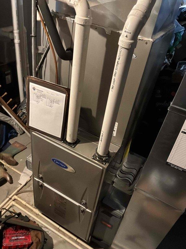 Completed comprehensive estimate for replacement of two non-functional residential air conditioning units and associated natural gas furnace systems located in basement. Both existing AC units determined to be beyond economical repair, requiring complete system replacement. Evaluated existing Carrier furnace installation, ductwork configuration, refrigerant line routing, and electrical connections to determine scope of replacement work. Documented current equipment specifications, venting systems including PVC intake and exhaust pipes, and existing infrastructure to provide accurate replacement recommendations for dual HVAC system installation.