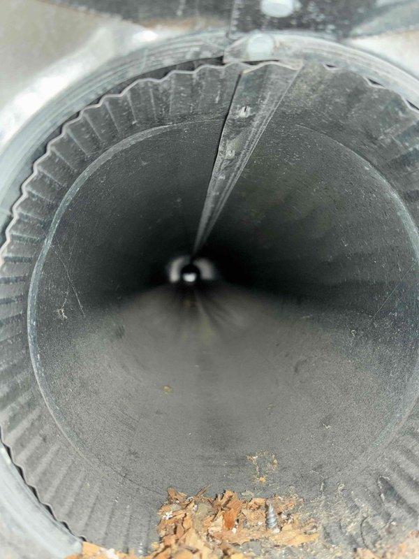 Responded to customer complaint of uneven airflow throughout home with some rooms receiving no air from vents. Performed diagnostic inspection of HVAC ductwork system. Upon inspection, discovered significant accumulation of dust, debris, and fibrous material inside flexible ductwork, with visible buildup on interior walls and bottom of ducts restricting airflow. Documented condition of duct interior showing corrugated surfaces coated in gray dust and brown particulate matter. Also inspected damper/fan blade mechanisms within metal ductwork, noting debris accumulation and general wear. Recommended professional duct cleaning and possible system rebalancing to restore proper airflow distribution throughout the home.