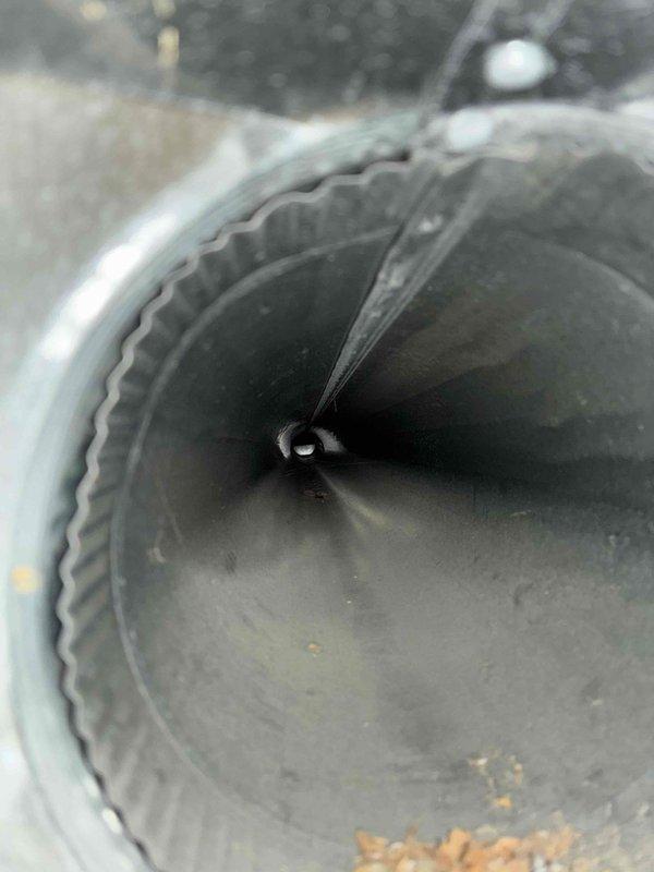 Responded to customer complaint of uneven airflow throughout home with some rooms receiving no air from vents. Performed diagnostic inspection of HVAC ductwork system. Upon inspection, discovered significant accumulation of dust, debris, and fibrous material inside flexible ductwork, with visible buildup on interior walls and bottom of ducts restricting airflow. Documented condition of duct interior showing corrugated surfaces coated in gray dust and brown particulate matter. Also inspected damper/fan blade mechanisms within metal ductwork, noting debris accumulation and general wear. Recommended professional duct cleaning and possible system rebalancing to restore proper airflow distribution throughout the home.