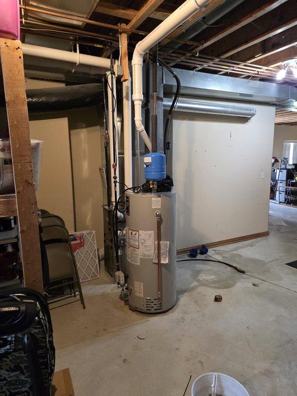 Completed installation of Bradford White power vented natural gas water heater, model RG1V5036N19, 50-gallon capacity with 40,000 BTU input rating. Unit installed in unfinished basement area with proper clearances per manufacturer specifications, connected copper supply piping, and integrated power vent system for safe combustion exhaust.
