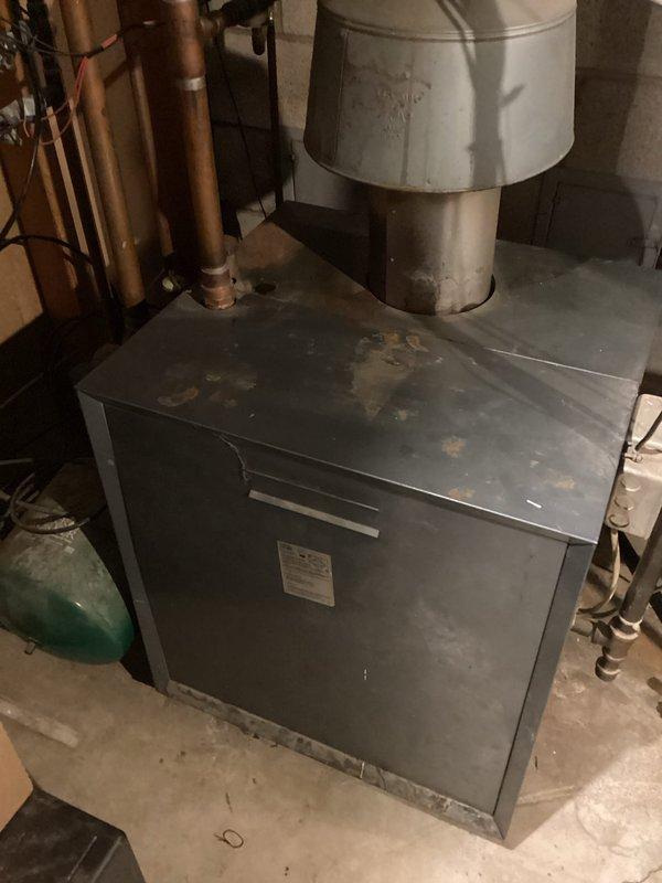 Completed diagnostic inspection of property with dual-zone HVAC system featuring two 1987-era AC condensers and air handlers located in attic and basement. Assessed aging infrastructure including disconnected boiler estimated at 50 years old, evaluated copper plumbing connections, ductwork configuration, and mechanical room conditions. Documented equipment condition and system components via photographs for replacement recommendations.