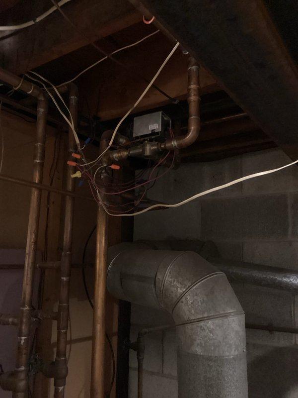 Completed diagnostic inspection of property with dual-zone HVAC system featuring two 1987-era AC condensers and air handlers located in attic and basement. Assessed aging infrastructure including disconnected boiler estimated at 50 years old, evaluated copper plumbing connections, ductwork configuration, and mechanical room conditions. Documented equipment condition and system components via photographs for replacement recommendations.
