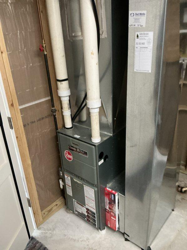 Responded to emergency HVAC replacement following fire damage caused by mouse nest in existing system. Completed full furnace and ductwork installation in basement utility space, including new gray furnace unit with proper venting through white PVC pipes, galvanized metal ductwork system, and electrical connections with black conduit routing.