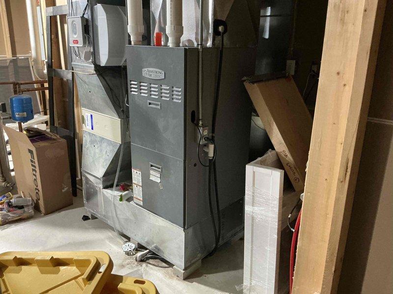 Provided comprehensive estimate for furnace replacement system after diagnosing failed blower motor resulting in loss of cooling capability. Assessed existing gray metal HVAC furnace unit located in unfinished basement area, evaluated current ventilation configuration with multiple white PVC condensate drain pipes, and documented exterior drainage system routing along foundation wall. Recommended complete furnace replacement due to blower failure and presented equipment options to restore heating and cooling functionality to residence.