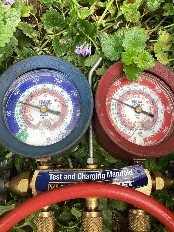 Responded to no cooling complaint on aging residential air conditioning system. Upon inspection, found system low on refrigerant with active leak causing condensate overflow onto floor. Connected manifold gauges to assess system pressures and refrigerant charge levels. Diagnosed control board operation and verified electronic components functioning properly with LED indicators showing normal status. Due to age of unit (10+ years) and extent of refrigerant leak, recommended system evaluation for repair versus replacement options.
