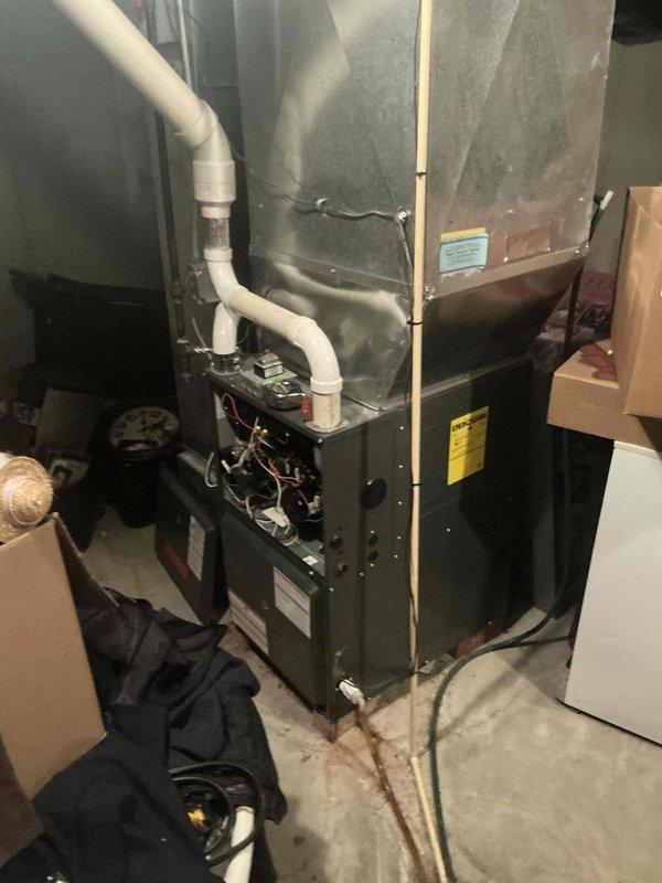 Completed comprehensive HVAC system replacement estimate for residential property with existing furnace installation in basement utility area. Documented current equipment configuration including electrical panel with main breaker and circuit distribution system, existing furnace unit with associated ductwork, and PVC condensate drainage system. Provided veteran's discount pricing for complete system replacement recommendation.