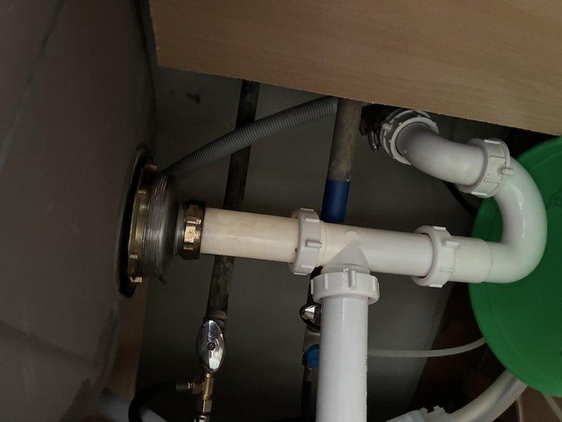 Responded to service call for sink leaking from strainer assembly after water use, particularly following dishwashing activities. Upon inspection of the under-sink plumbing, diagnosed the issue with the drain strainer connection and associated P-trap assembly. Evaluated the chrome drain tailpiece, slip-joint fittings, and white PVC pipe configuration to identify the source of the leak and completed necessary repairs to restore proper drainage function.