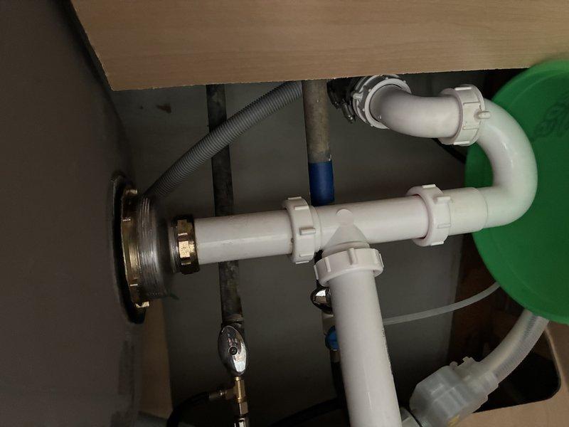 Responded to service call for sink leaking from strainer assembly after water use, particularly following dishwashing activities. Upon inspection of the under-sink plumbing, diagnosed the issue with the drain strainer connection and associated P-trap assembly. Evaluated the chrome drain tailpiece, slip-joint fittings, and white PVC pipe configuration to identify the source of the leak and completed necessary repairs to restore proper drainage function.