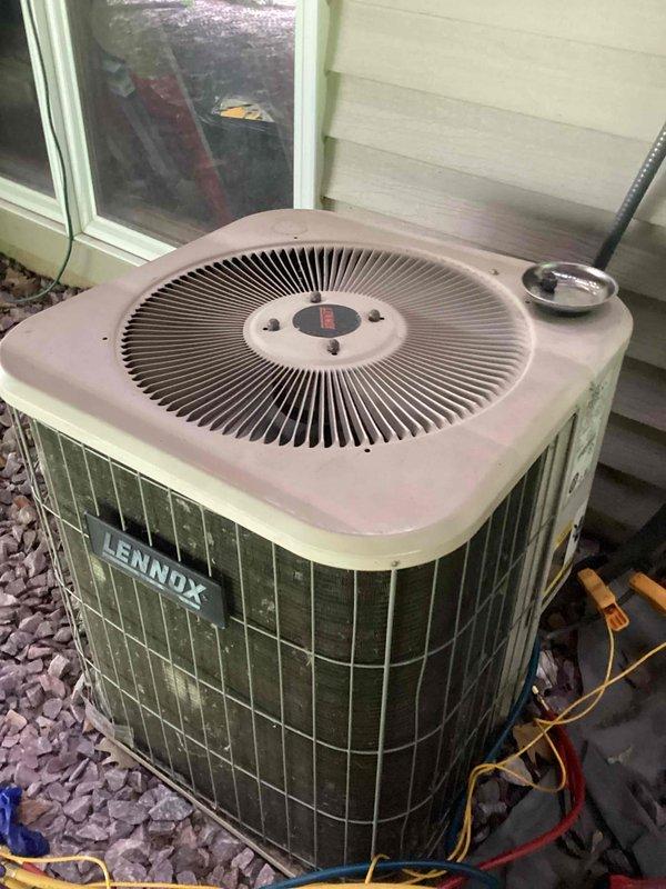 Responded to no cooling call for dual-unit system with both units located in basement. Upon arrival, confirmed upper unit operational while lower unit completely non-functional. Performed diagnostic evaluation of non-operational unit, inspecting both indoor air handler components and outdoor Lennox condenser unit. Documented system condition including refrigerant line connections, condenser coil status, and overall equipment condition showing signs of age and weathering.