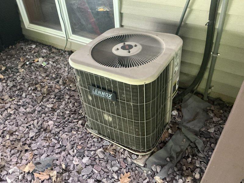 Responded to emergency AC service call and conducted comprehensive system evaluation for replacement estimate. Assessed existing Lennox outdoor condensing unit and indoor air handler/furnace system, documented current equipment condition showing age-related wear and outdoor exposure, photographed installation configuration including ductwork connections, PVC drainage lines, copper refrigerant piping with shutoff valve, and electrical conduit routing for replacement planning purposes.