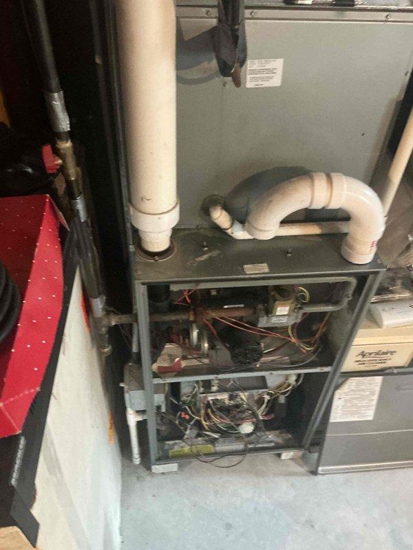 Responded to emergency service call for aging HVAC system that was temporarily restored to operation but requires replacement evaluation. Conducted comprehensive assessment of existing Arcoaire furnace installation, including inspection of internal components, blower motor assembly, control boards, electrical wiring harnesses, and burner assemblies. Evaluated PVC condensate drain line configuration and venting system integrity. Documented current system condition through detailed photography showing cabinet construction, mechanical components, and Aprilaire air cleaner integration. Provided estimate for complete furnace and air conditioning system replacement based on equipment age and observed wear patterns.