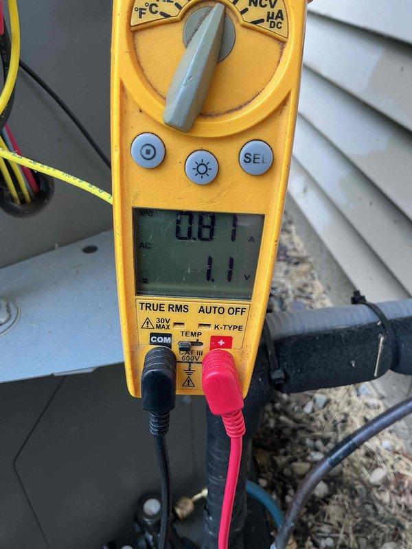 Completed comprehensive AC tune-up on outdoor condensing unit, performing standard maintenance procedures including electrical testing with digital multimeter to verify proper amperage and voltage readings. Unit operating within normal parameters; condenser positioned on proper pad with adequate clearance and gravel base for drainage.