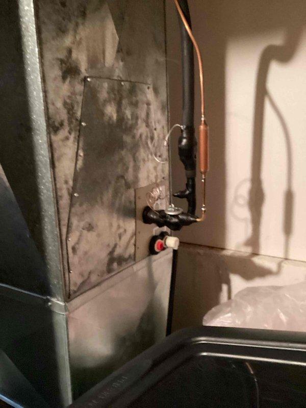 # HVAC Service Report - No Cool Condition

Responded to a no cooling call on a residential HVAC system less than 10 years old. Upon arrival, conducted a comprehensive system diagnostic to identify the cause of cooling failure. Inspected the furnace unit and associated ductwork components located in the basement mechanical room.

Performed visual inspection of the air handler, ductwork, and refrigerant lines. Examined copper refrigerant piping for proper installation and potential leak points. Checked condensate drain system including black plastic drain valves and fittings for proper operation and blockages. Assessed the condition of metal ductwork, noting weathering and surface discoloration consistent with normal system operation in a basement environment.

Evaluated furnace control panel operation and verified proper electrical connections. Inspected PVC vent pipes for proper exhaust ventilation. Tested system controls and thermostat communication to identify cooling mode failure po