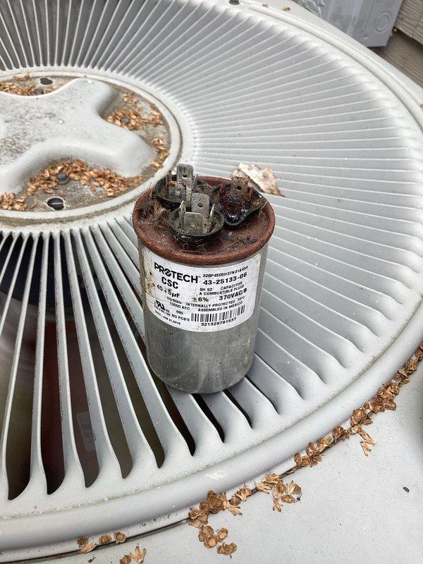Responded to no cooling complaint on residential air conditioning system. Upon arrival, found outdoor condensing unit inoperative. Visual inspection revealed heavily corroded dual run capacitor with rust damage on terminal connections and cap, along with significant debris accumulation on condenser fan grille. Connected manifold gauge set to system for diagnostic testing. Determined failed capacitor was preventing compressor and condenser fan motor from starting. Replaced defective capacitor with new PROTECH unit, ensuring proper electrical connections and secure mounting. Cleaned debris from condenser fan grille to restore adequate airflow. Cycled system on, verified compressor and fan motor operation, and confirmed proper refrigerant pressures. System restored to normal cooling operation.